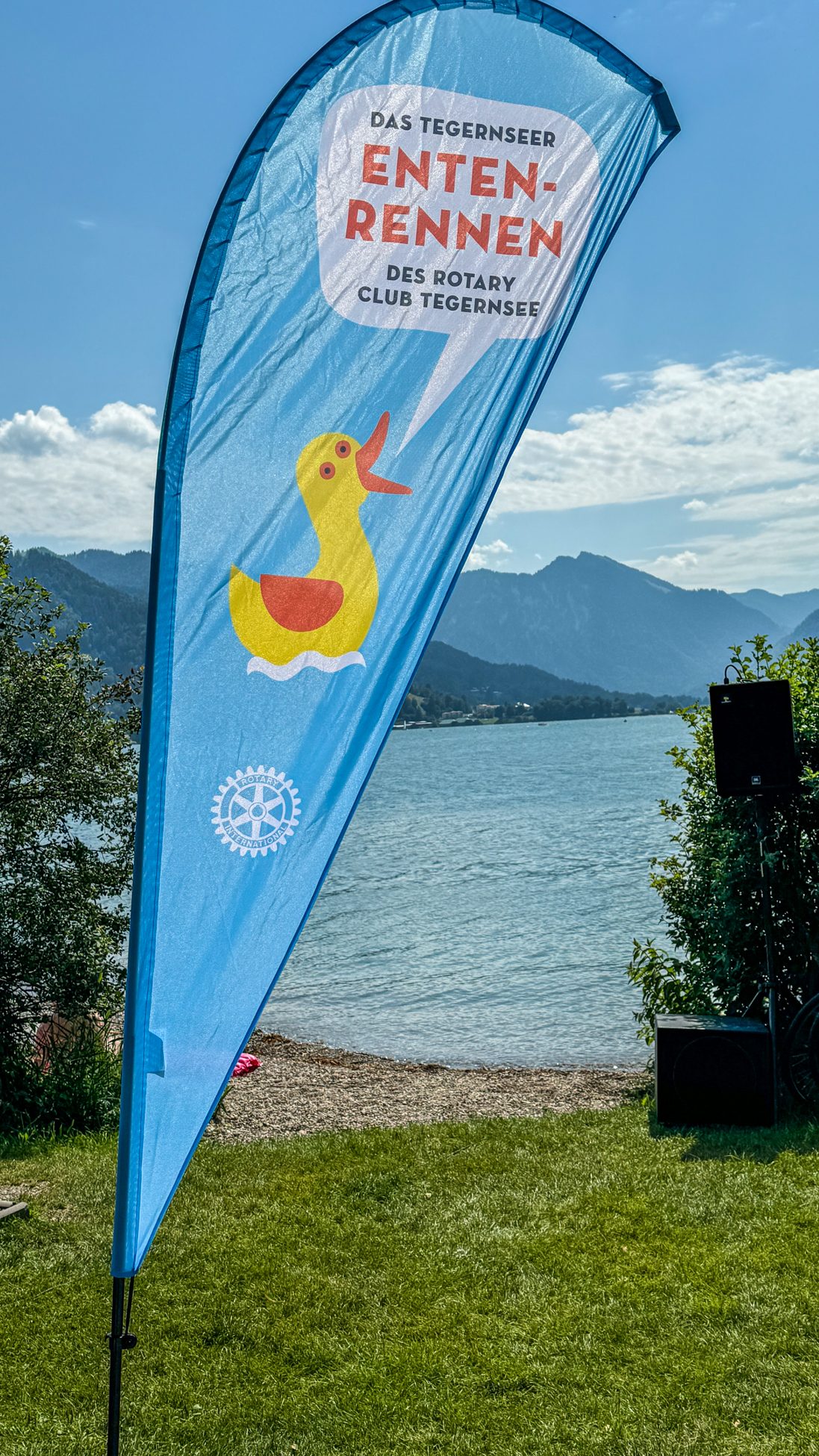 Beachflag des Tegernseer Entenrennens vor Tegernsee und Bergen